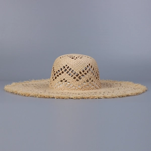 Detail view of handmade raffia sun hat with wide brim and intricate openwork weave