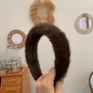 Détail d'un serre-tête en fausse fourrure de vison marron foncé montrant sa texture