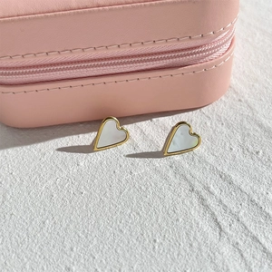 Gros plan de boucles d'oreilles en forme de cœur avec incrustation de nacre et doré