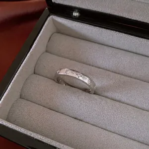 Brushed silver star ring with inlaid cubic zirconia crystals on gray velvet