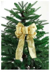 Close-up of a sparkling gold glitter bow decoration on a green Christmas tree branch