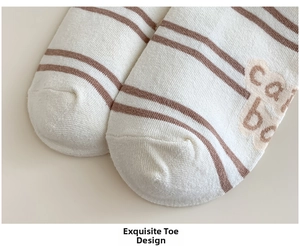 Close-up of the beige and brown striped cotton sock showing fine knit toe and text detail