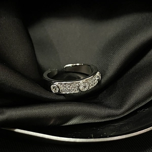 Detailed view of silver butterfly ring with micro-pave diamonds on dark satin fabric