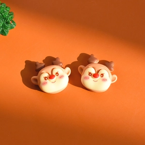 Close-up of cute resin reindeer charms for DIY crafts on a warm orange background