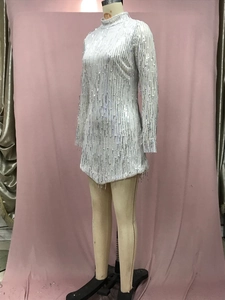 Vista de cerca del vestido blanco de lentejuelas con flecos y cuello alto liso