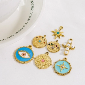 Goldfarbene Anhänger-Set mit bösem Blick, Sternenmotiven und einem Perlenkreuz-Design