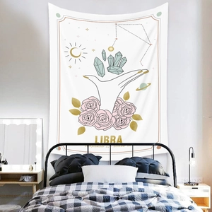 Detail of Libra zodiac tapestry featuring pink roses and crystals on a bedroom wall