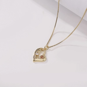 Macro view of gold heart pendant with MOM letters and micro-pave cubic zirconia star detail
