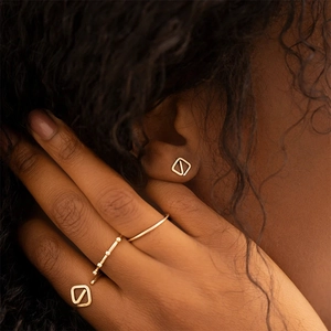 Detail of s925 silver triple-layered cross open ring and square stud earrings on model