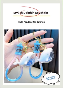 Detail of blue dolphin keychain with star sequins and a gold lobster clasp attachment