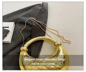 Detail of the golden moon-shaped handbag featuring woven texture and round metal handle