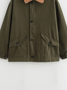Detail of army green workwear jacket featuring brown corduroy collar and cargo pockets