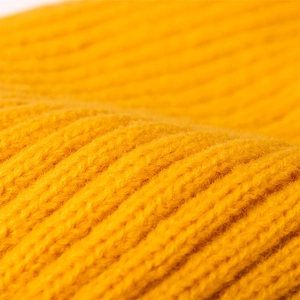 Ginger yellow ribbed knit beanie for women and men, warm stretchy winter hat close-up view