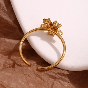 Detail of 18K gold plated flower ring featuring micro-pave cubic zirconia on white surface