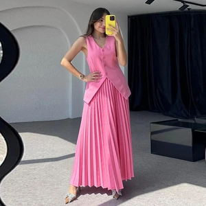 Schickes Set aus rosa ärmelloser Weste und plissiertem Maxirock für modische Damen