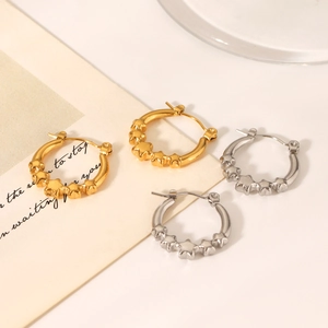 Detailed view of gold and silver stainless steel star hoop earrings on a decorative card