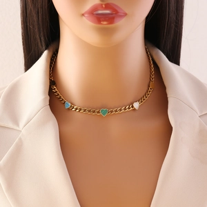Gold Cuban link heart necklace with blue, green and white enamel charms on a model