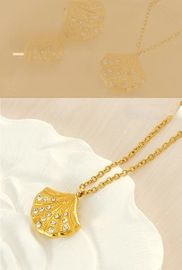 Detail of 18K gold plated shell pendant necklace with crystal zircons and fan shape