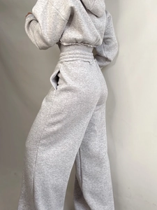 Women's grey two-piece tracksuit featuring a short zip hoodie and wide-leg sports pants