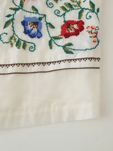 Gros plan d'un gilet blanc avec broderie florale et texture en coton et lin
