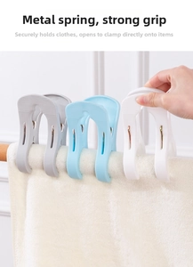 Detail of strong plastic quilt clips with metal springs securing a towel on a wooden rail