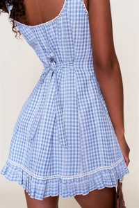 Back view detail of blue and white plaid dress featuring tie-waist and ruffle hem details