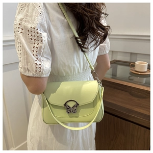 Detailed view of mint green shoulder bag featuring a stylish butterfly metal clasp