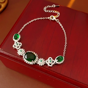 Macro detail of luxury vintage green gemstone flower bracelet on red wood jewelry box