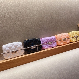 Fila de mini bolsos de gelatina en cinco colores con diseño acolchado y cadena de oro