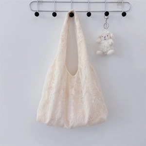 Detailed view of cream-white lace embroidery pattern on a soft summer tote bag