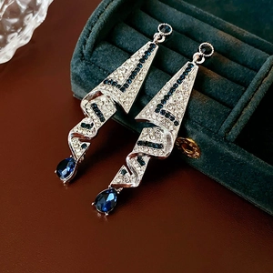 Detailed view of silver satin drop earrings with blue crystal and micro-pave rhinestones