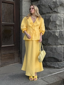 Detail view of yellow V-neck crop top with tie-front and matching A-line maxi skirt set