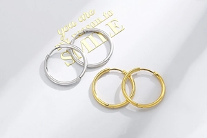 Detailed close-up showing minimalist gold and silver stainless steel hoop earrings
