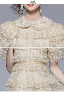 Detailed view of ruffled lace collar with delicate embroidery on a beige A-line dress