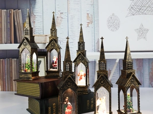 Close-up of bronze vintage lantern with snowy Christmas scene on antique books