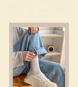 Close-up of pastel pink striped cotton socks paired with casual denim and canvas shoes
