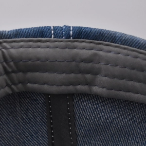 Macro shot of the denim baseball cap interior showing durable stitching and sweatband