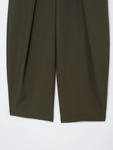 Detailed close-up showing texture and pleated hem of olive green wide-leg trousers