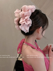 Detail of pink oversized bow hair claw clip showing elegant layered fabric texture