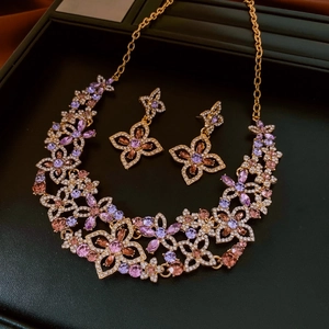 Detailed view of hollow flower jewelry set with gold metal and sparkling crystals