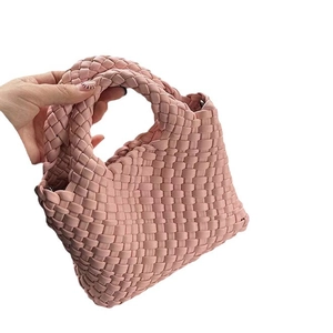 Chic pink woven leather bucket bag with top handle shown on a clean white background