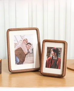 Detail of solid walnut wood picture frames with rounded corners on a wooden desk