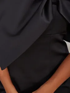 Détail d'une robe bustier noire élégante avec des textures de plis asymétriques