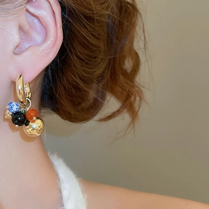 Detailed view of vintage gold hoop earrings with colorful multi-stone grape cluster charms