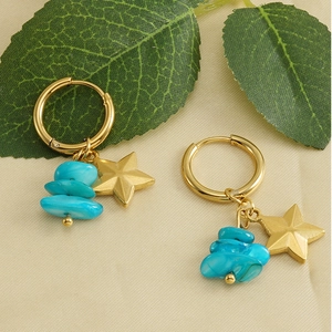 Detail of 18k gold star earrings with stacked blue natural stone beads on a fabric background