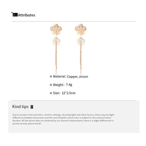 Detailed view of long gold hollow floral tassel earrings with zircon and copper material