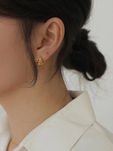 Minimalist S925 sterling silver gold twisted hoop earrings worn on a model's ear