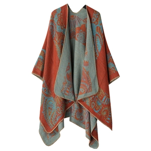 Detail of red and teal paisley pattern on knitted shawl with neat stitched edges