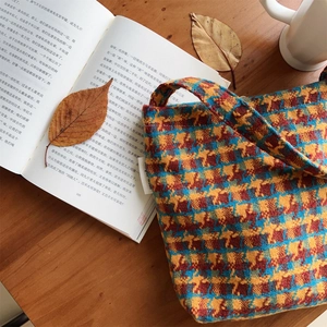 Detailed macro view of woven plaid fabric texture and woven label on retro shoulder bag