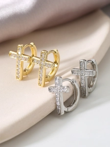Macro view of gold and silver cross hoop earrings with sparkling cubic zirconia stones